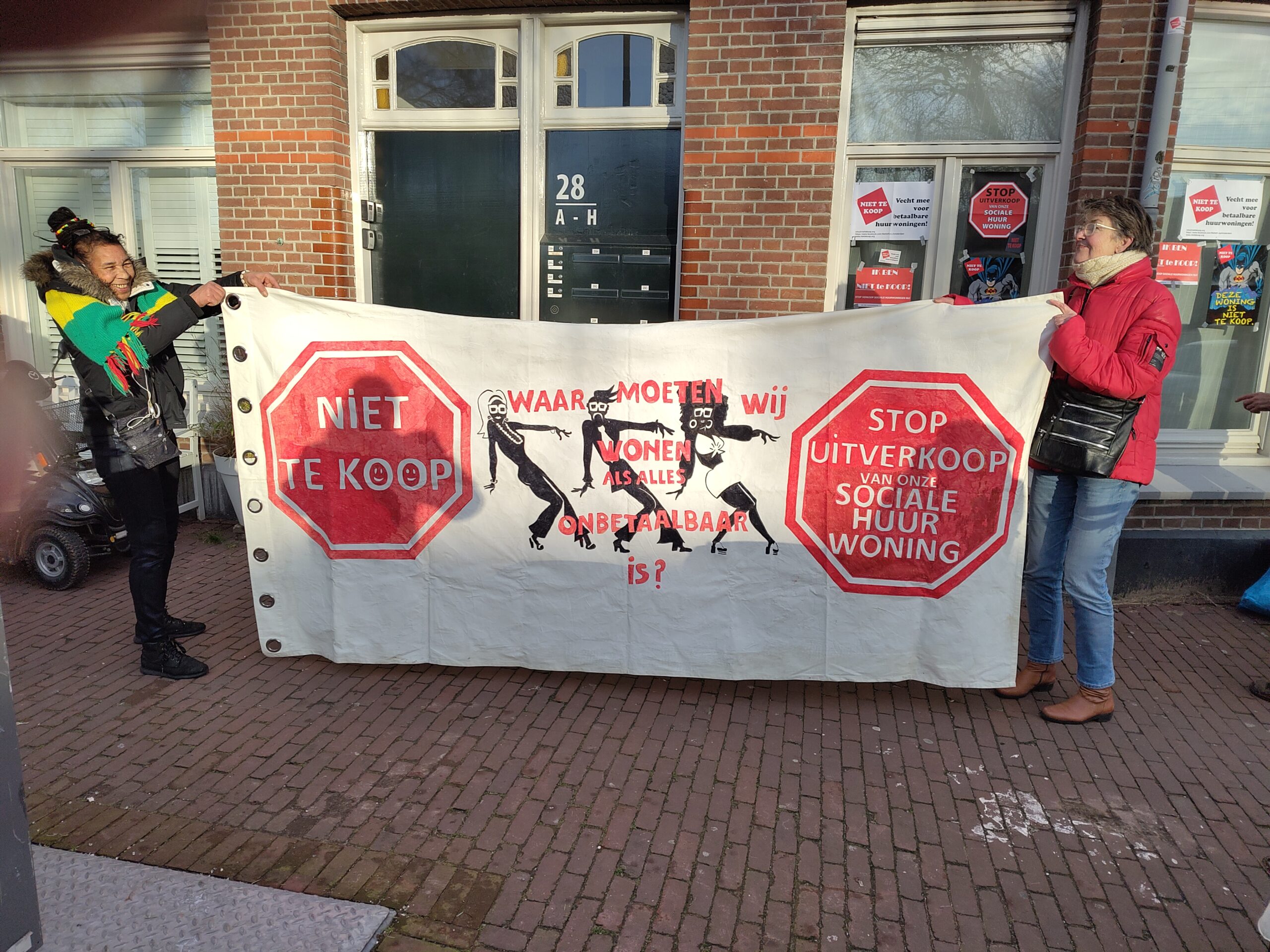 Nieuw spandoek wordt getoond: 
Waar moeten wij wonen als alles onbetaaldbaar is?